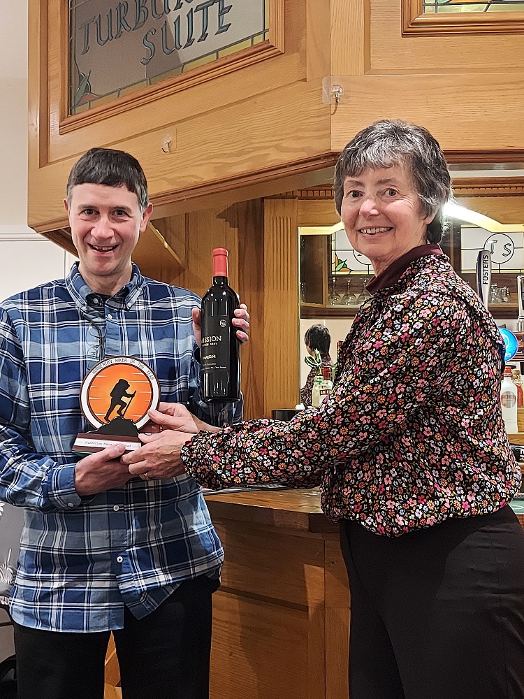 Lesley presents John with the 2023 Hubberton Hiker of the Year award.